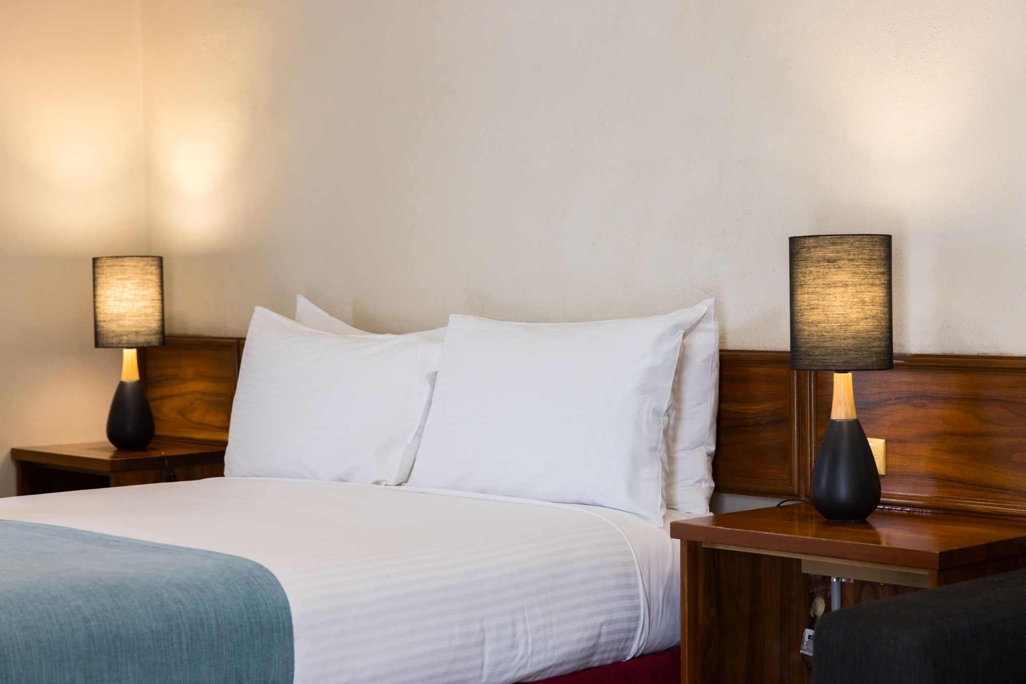 Seaton Arms Motor Inn queen bed with white linen in comfortable room setting.